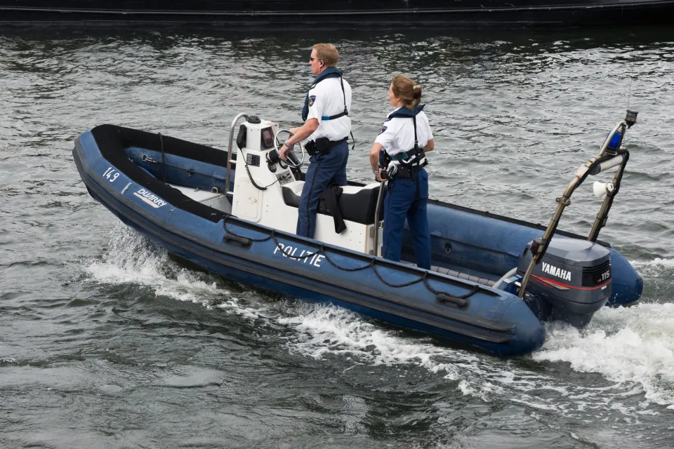 Two police officers on a patrol boat during the Sail 2010 boat parade in Amsterdam.
