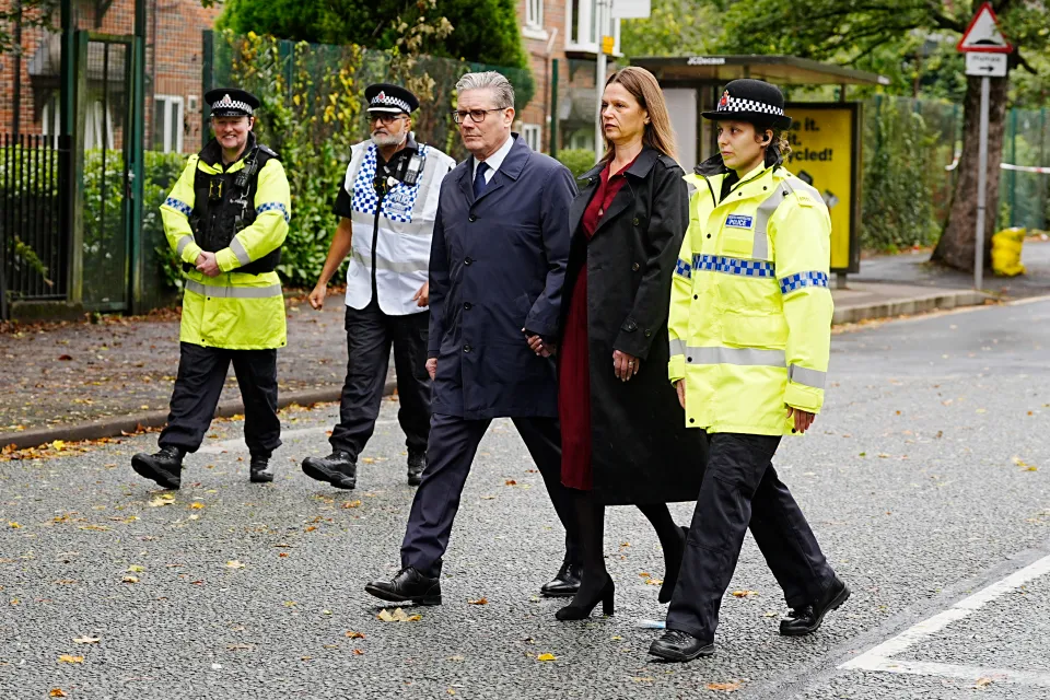 Prime Minister Sir Keir Starmer and Lady Victoria Starmer walk with police officers during a visit to the Heaton Park Hebrew Congregation synagogue.