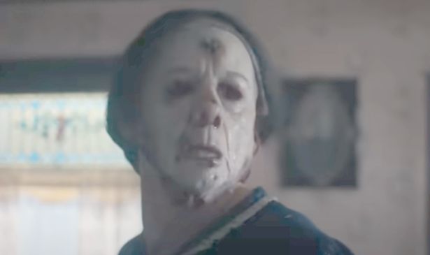 A man in a mask looks over his shoulder