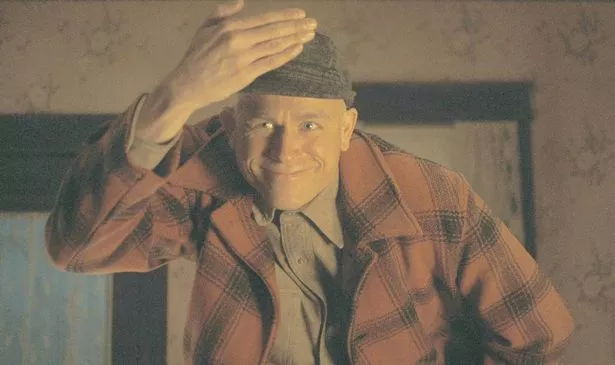 A man holds a hand in the air near his face