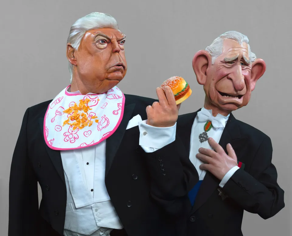 Illustration of Spitting Image puppets of Donald Trump and King Charles III, with Trump wearing a bib with chips and Charles holding a hamburger.