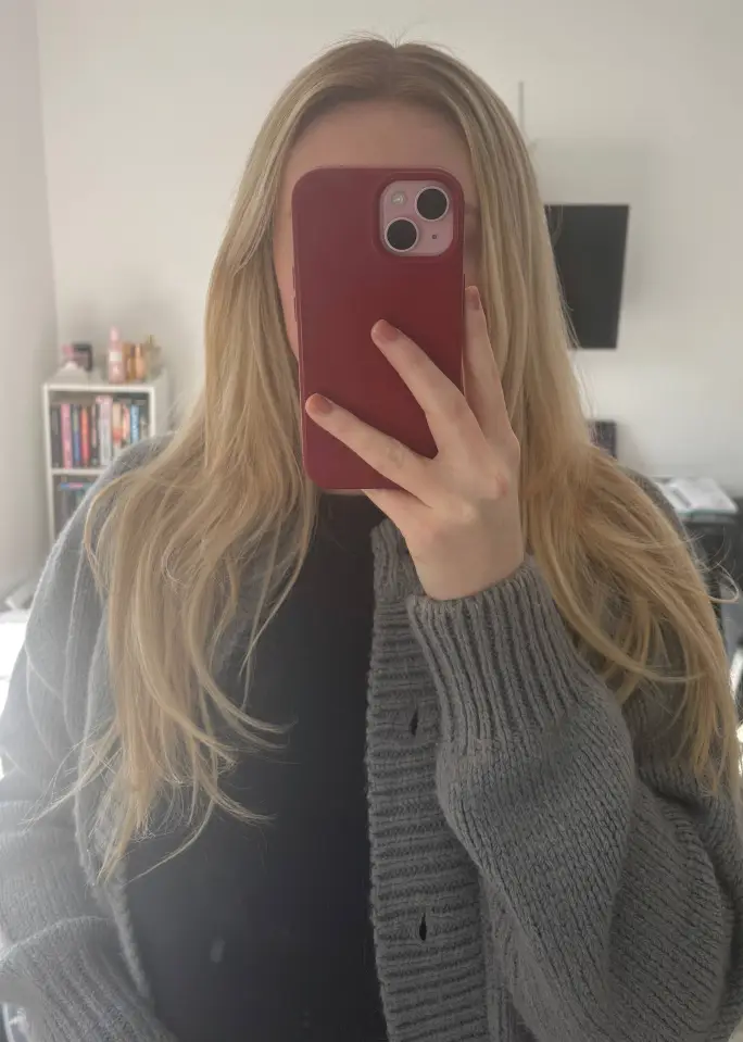 Woman holding phone in front of her face.