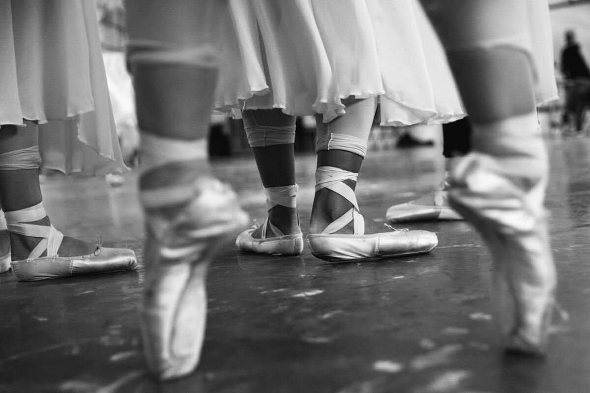 Los Angeles Ballet dancers in pointe shoes stretch before beginning rehearsals in 2015.