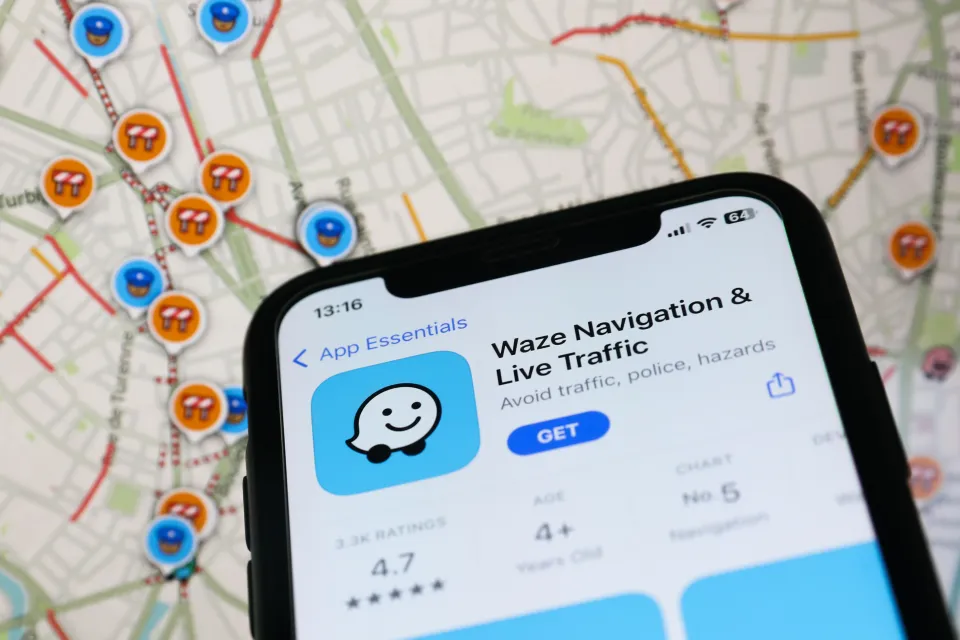 Illustration of the Waze app on an iPhone in front of a map with Waze icons.