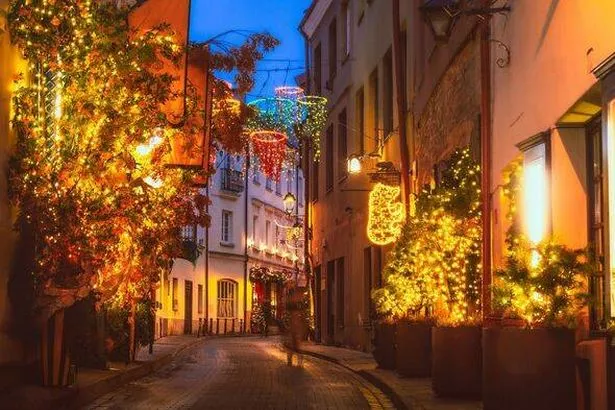 Vilnius, Lithuania - 30th november, 2024: tourist walks in stikliai street famous Vilnius old town area full of festive holidays decorations. Xmas mor