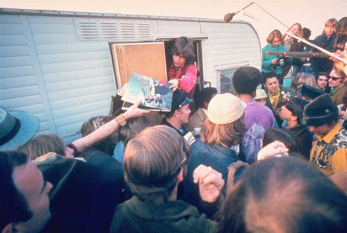 Rolling Stones lead singer Mick Jagger signs autographs for fans at the Altamont Race Track
