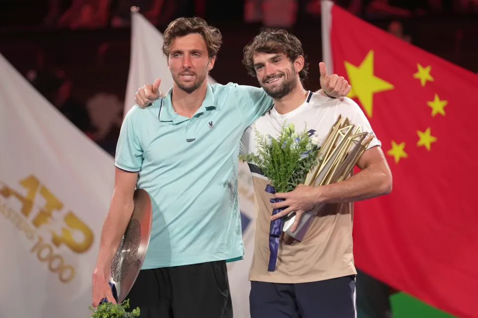 Valentin Vacherot and Arthur Rinderknech embracing on the winners podium.