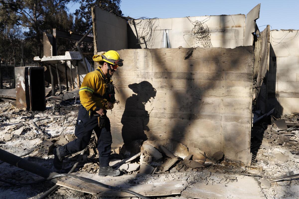 Firefighter puts out a hotspot fire in the Pacific Palisades on Sunday, Jan. 12, 2025 in Los Angeles, CA.