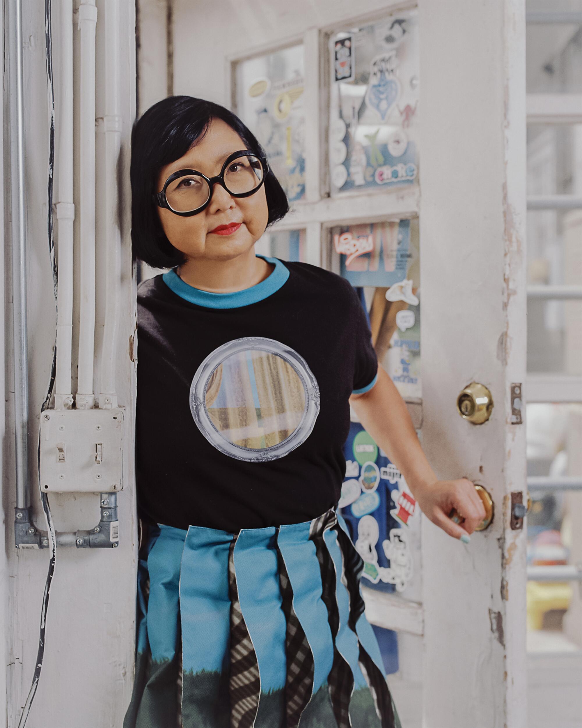 Shirley wears Leeann Huang t-shirt, skirt and shoes, We Love Colors tights and l.a. Eyeworks glasses here and below.