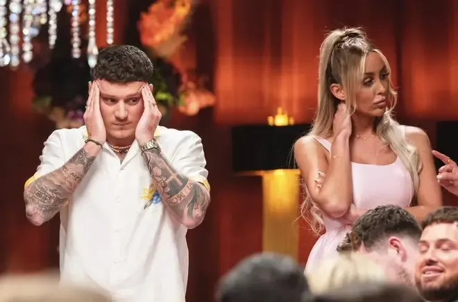 JJ covering his ears with his hands next to Ella Morgan who has her hand to her neck.