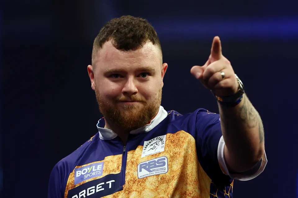 Josh Rock of Northern Ireland celebrates a throw during a darts match.
