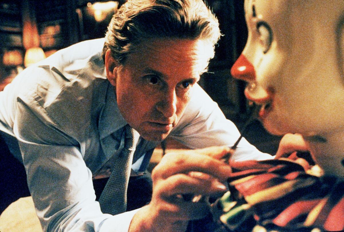 A man peers into the mouth of a clown.