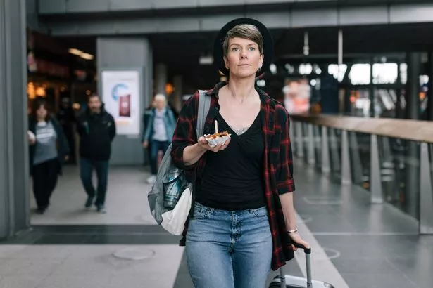 Woman walking through an airport with luggage