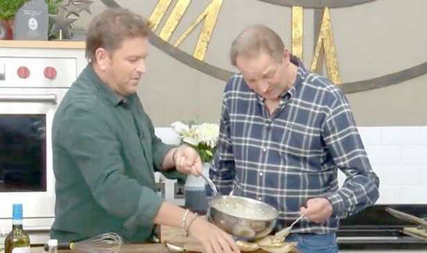 Two men cook in a kitchen