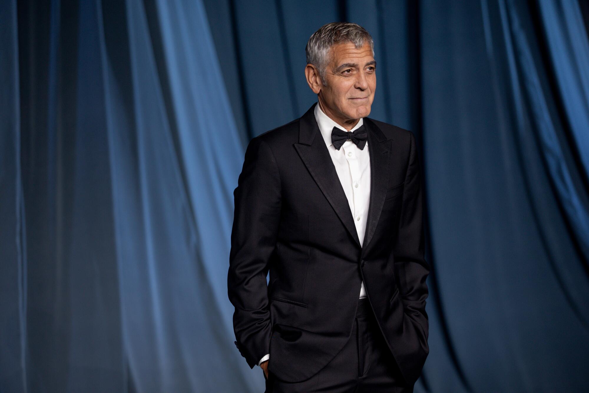 George Clooney poses in a tux.