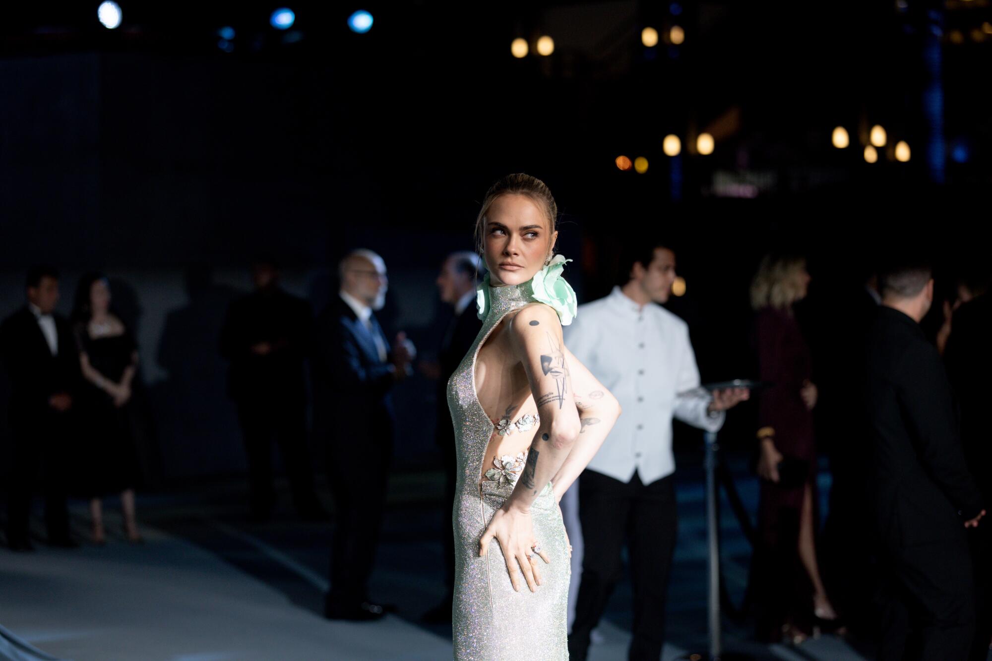 Cara Delevingne wears a silver gown.