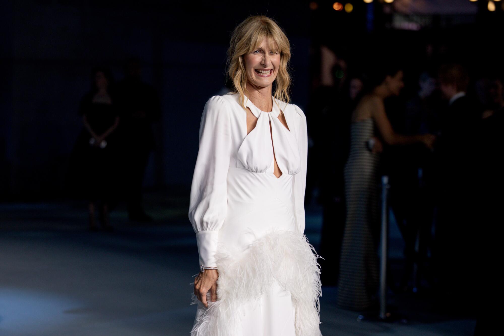 Laura Dern wears a white gown with feathers.