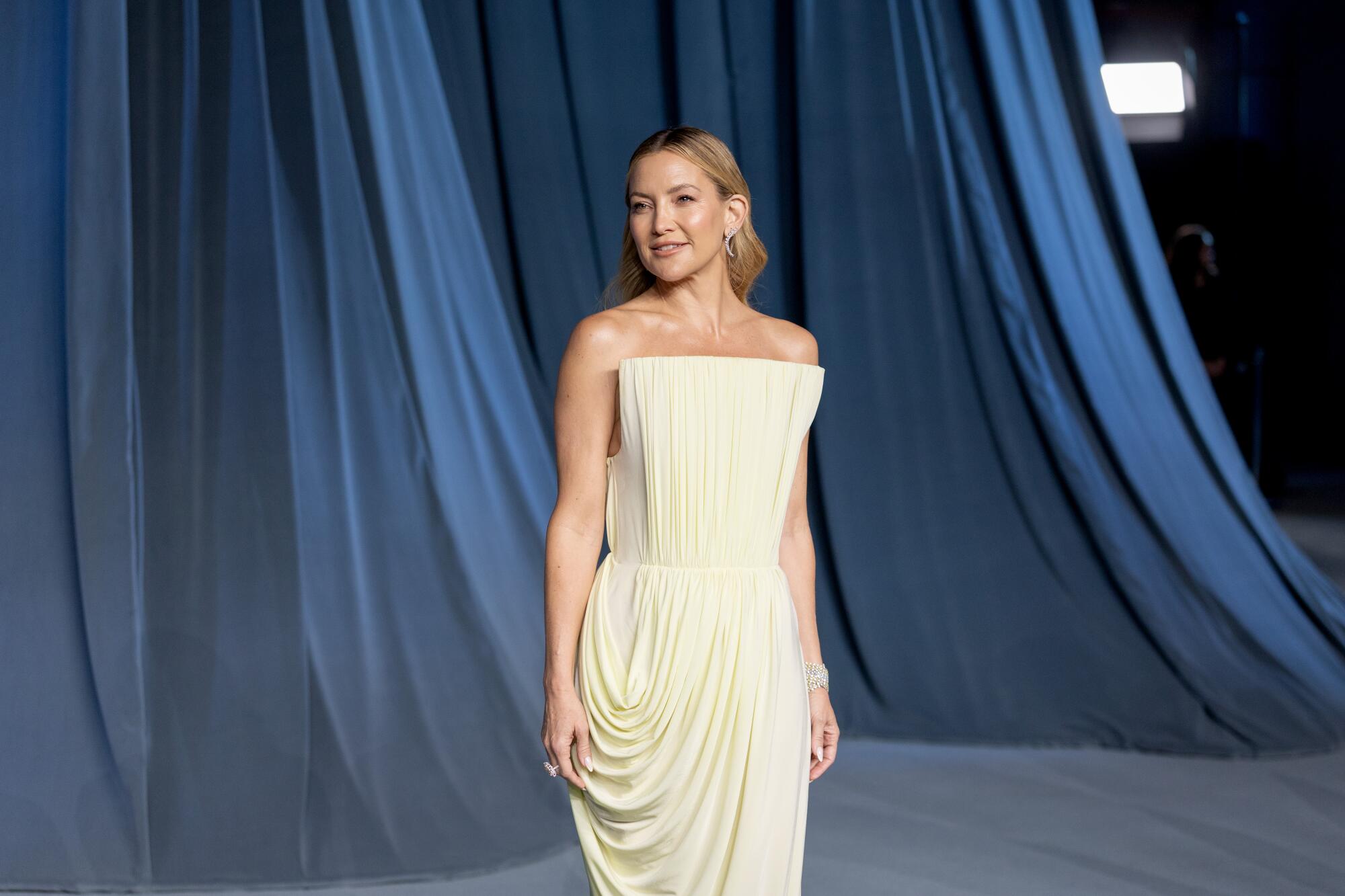 Kate Hudson wears a strapless white gown.