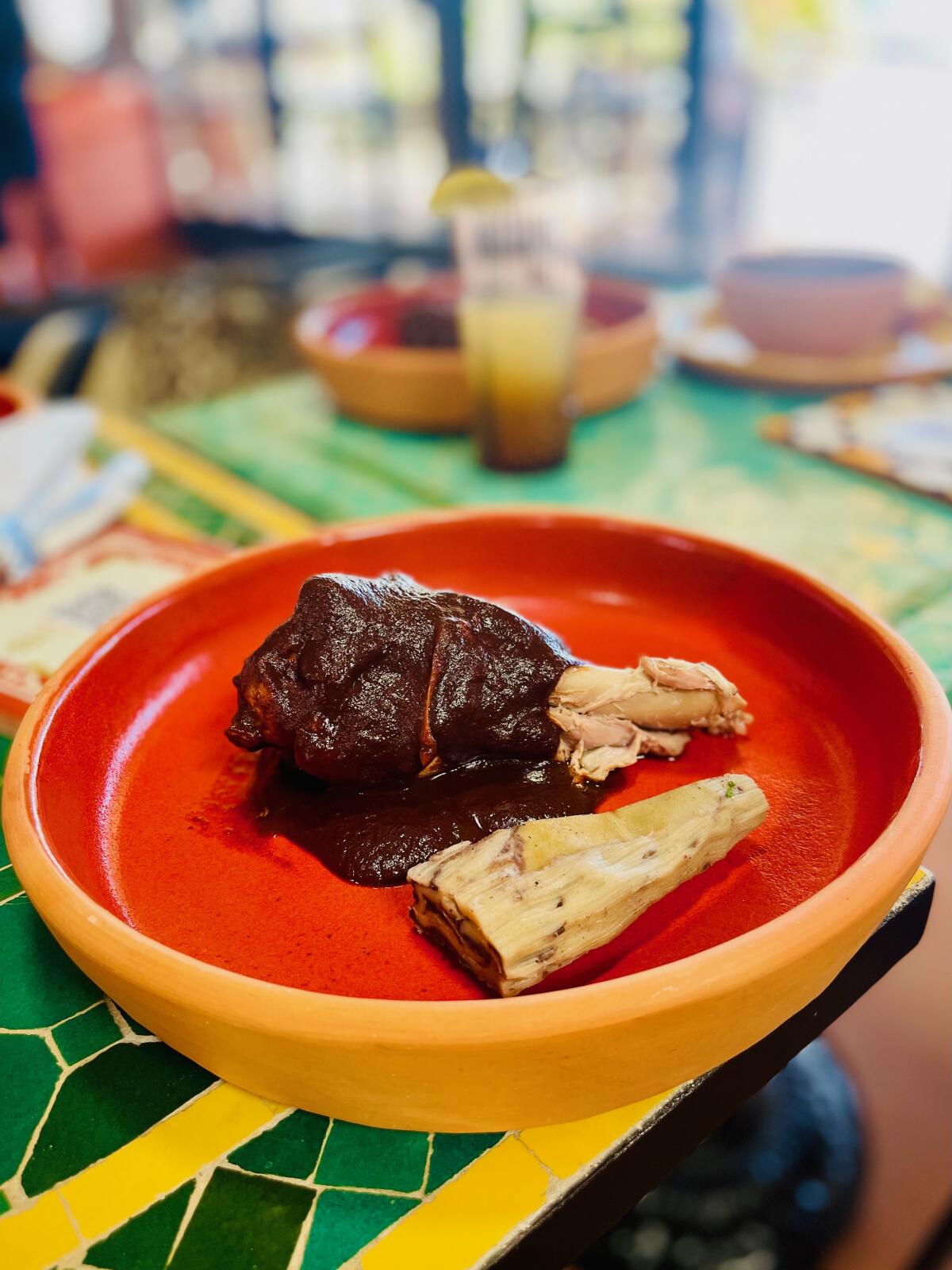 Oct 16, 2025--Mole-covered turkey leg with a black bean tamal from Lugya'h at Maydan Market.