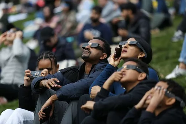 People gather to view the solar eclipse at Riverdale Park on April 08, 2024 in Toronto, Ontario