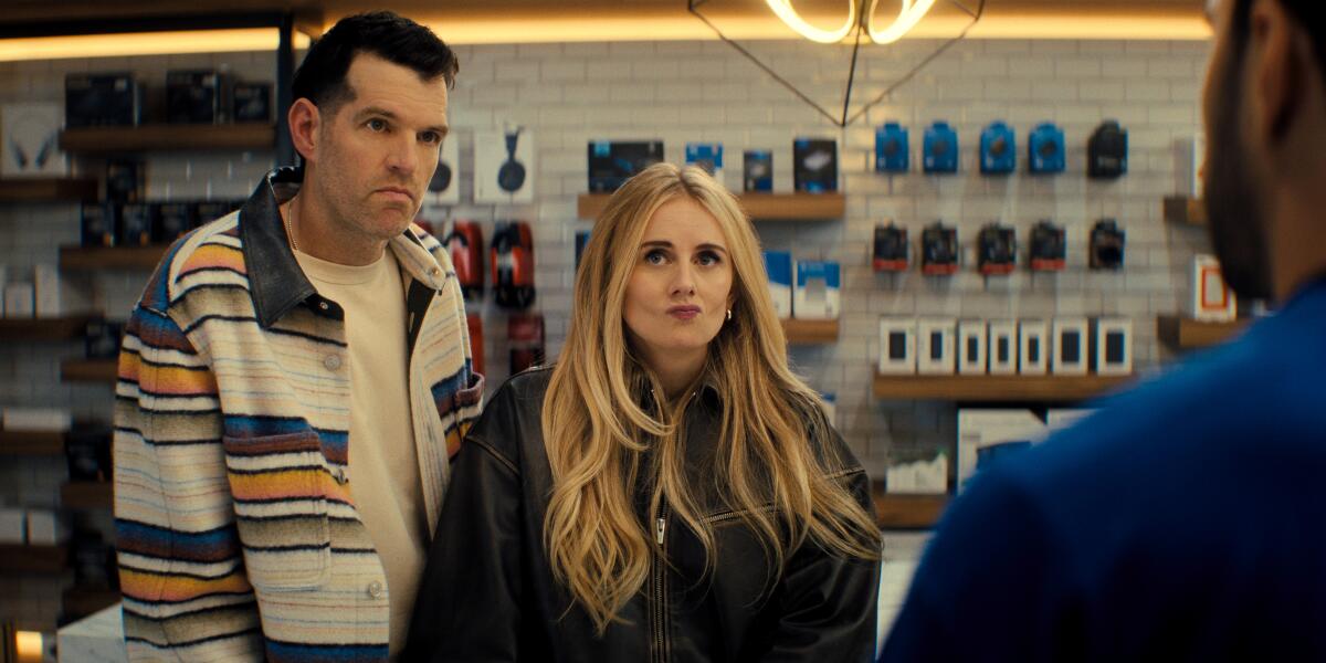 A man and a woman stand side by side in a store