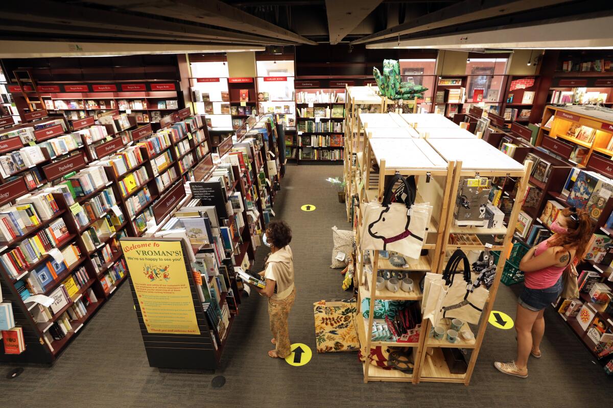 People browsing through shelves inside a bookstore.