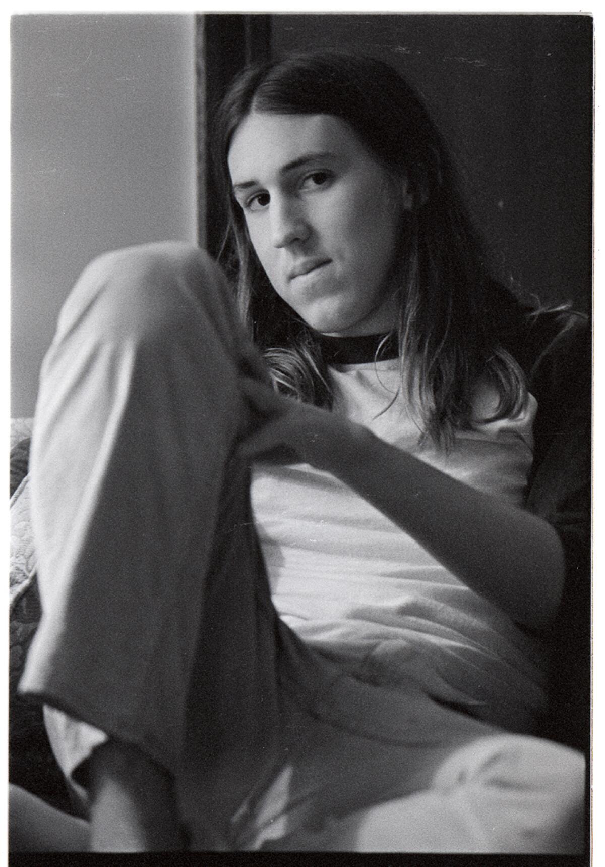 A young Cameron Crowe sits with his leg bent up.