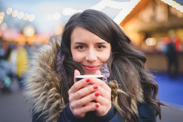 Woman enjoying a cup of mulled wine at the Christmas market