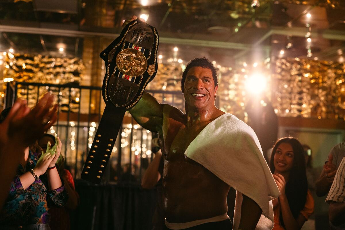 A bulked-up fighter hoists a championship belt.