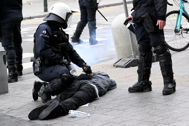 Riot police arrest a protester on the sidelines of a demonstration during a national day of action against the austerity of the federal Arizona government, in Brussels on October 14, 2025. The strike is the last in a series to hit the European country since Flemish nationalist Bart De Wever took office as prime minister in February. Grappling with a budget deficit whose size violates European Union rules, the government is looking to reform pensions and make other savings that have infuriated trade unions. (Photo by Nicolas TUCAT / AFP)