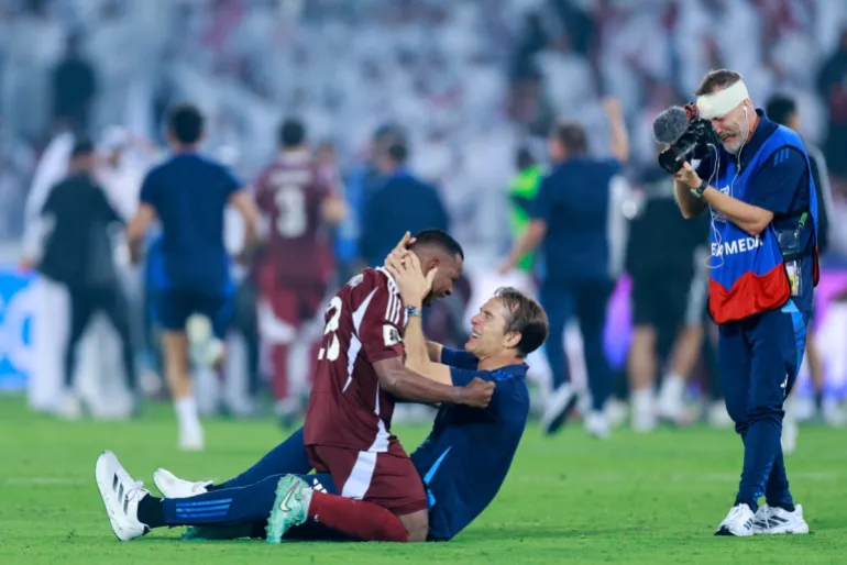 Qatar's defender #23 Assim Madibo celebrates with Qatar's Spanish coach Julian Lopetegui after the FIFA World Cup 2026 Asian qualifier