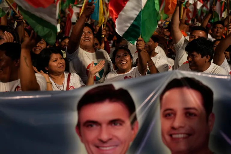 Supporters of Rodrigo Paz wave flags and hold up a banner with his face and his running mate's.