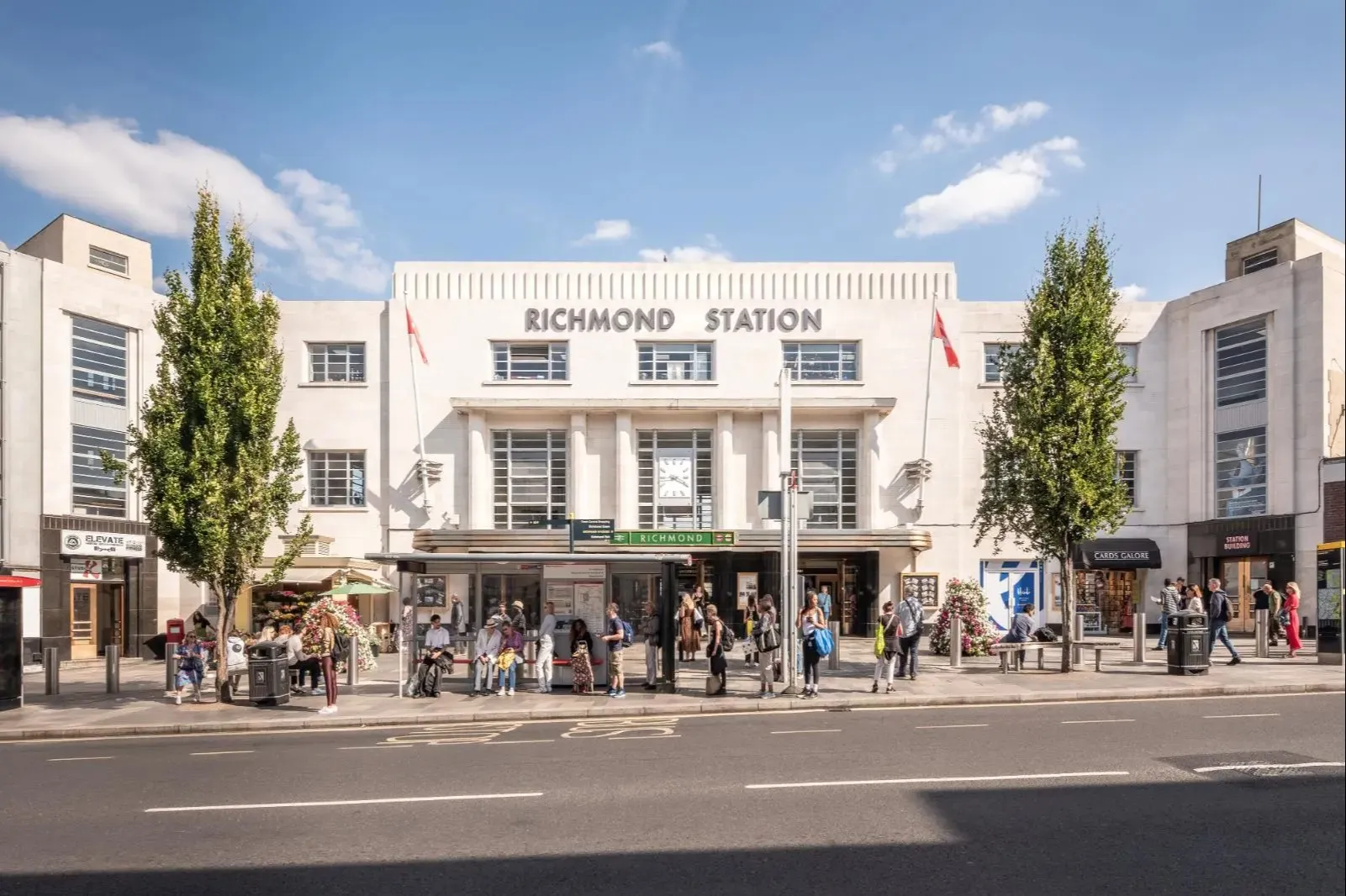 Exterior view of the refurbished Art Deco Richmond railway station with people waiting outside.