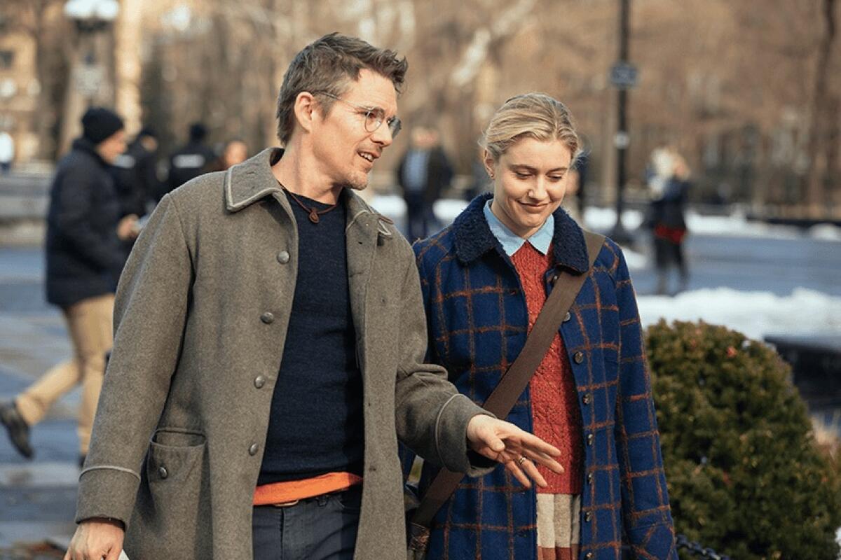 Two people walk in an outdoor park.