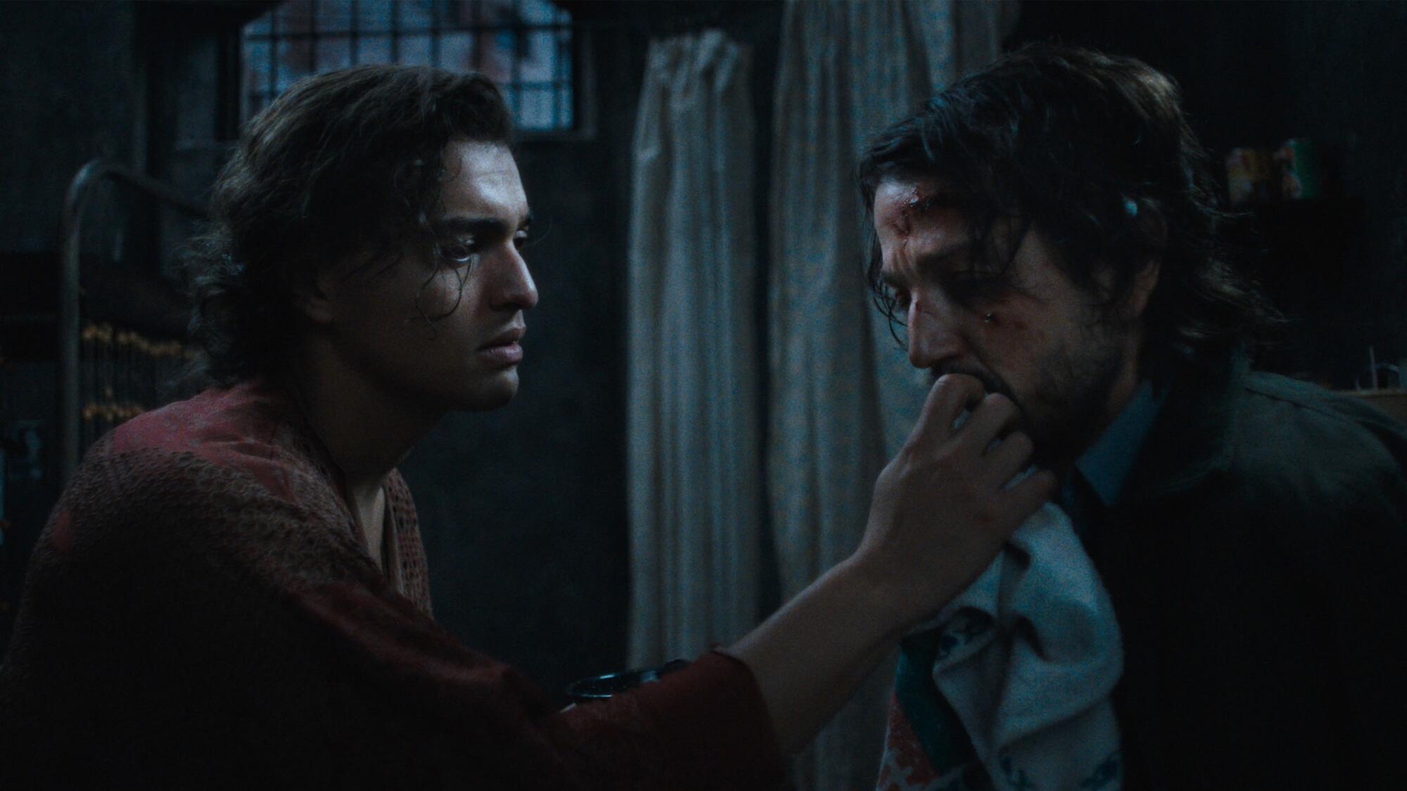A man touches another man's lips.