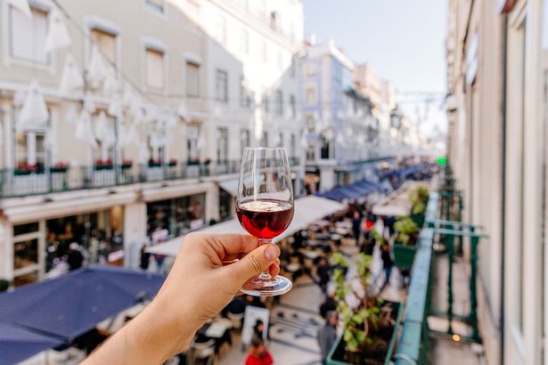 A person holding up a drink in Lisbon