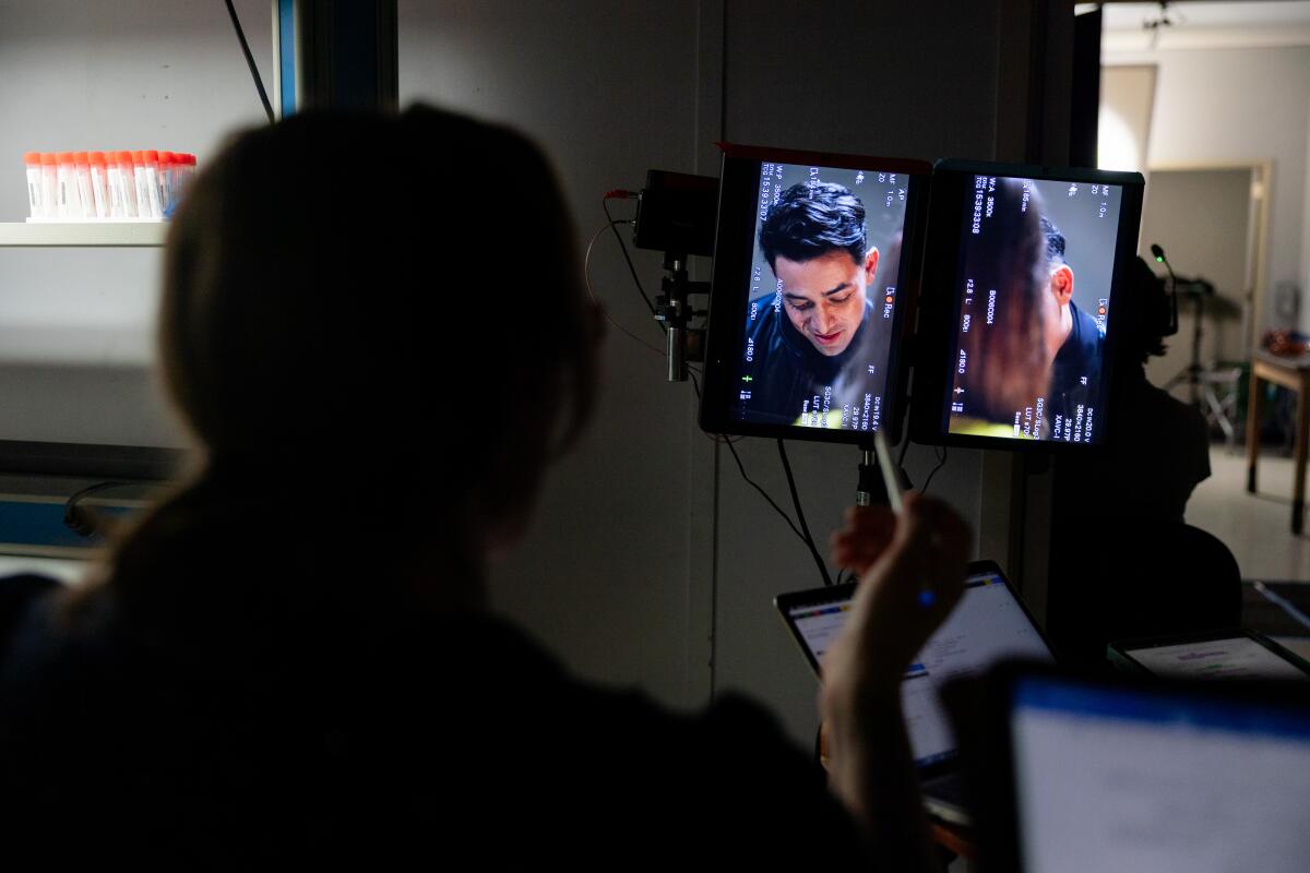 A person looks at dual vertical monitors during a scene of a film