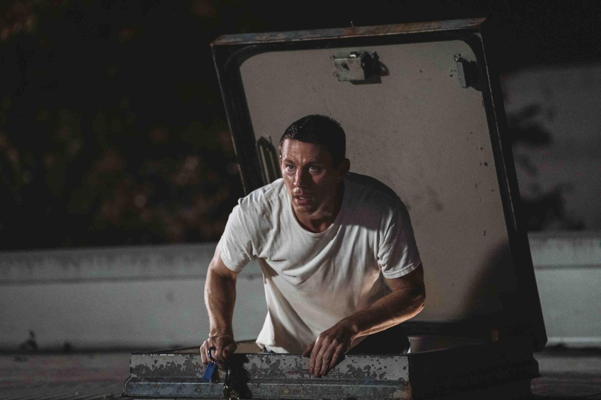 A man coming through a hatch in a roof looks surprised.