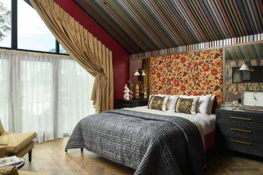 Bedroom with large floral headboard and gray quilt.