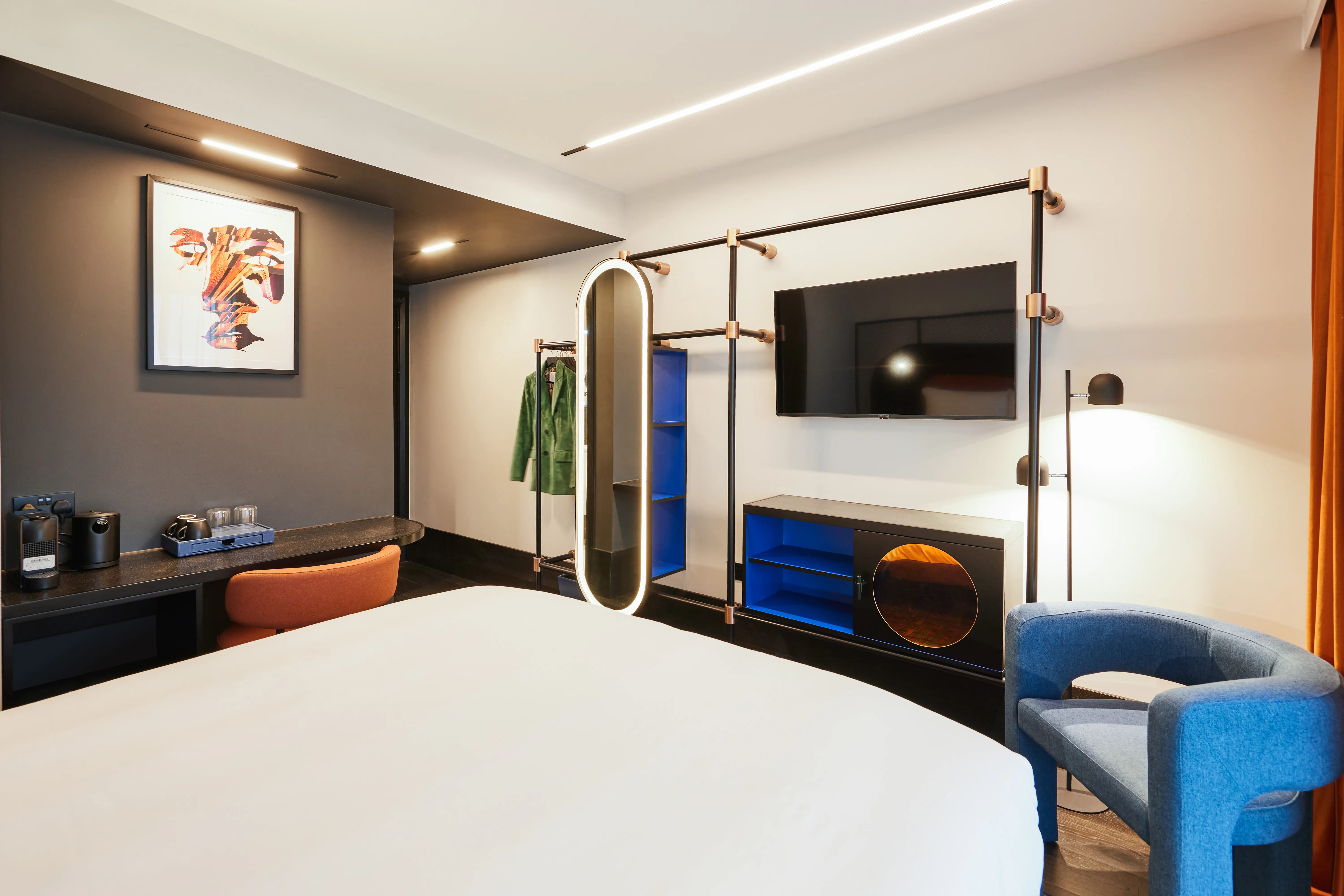 Hotel room with bed, TV, and seating area.
