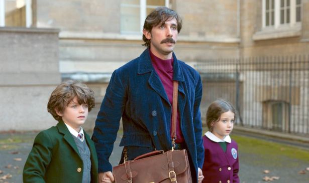 A man holds hands with a girl and a boy