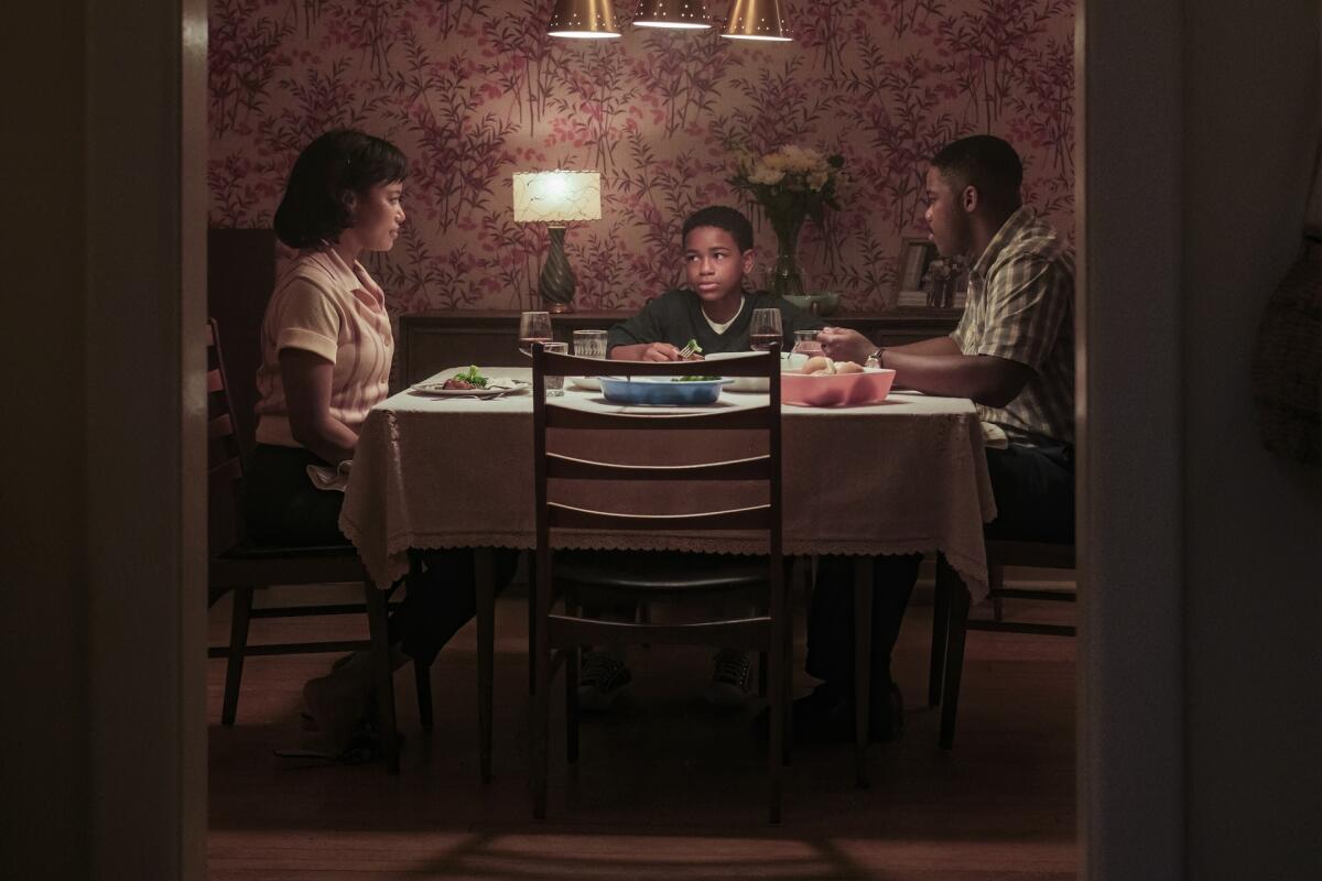 A woman, a boy and a man sit around a dinner table.