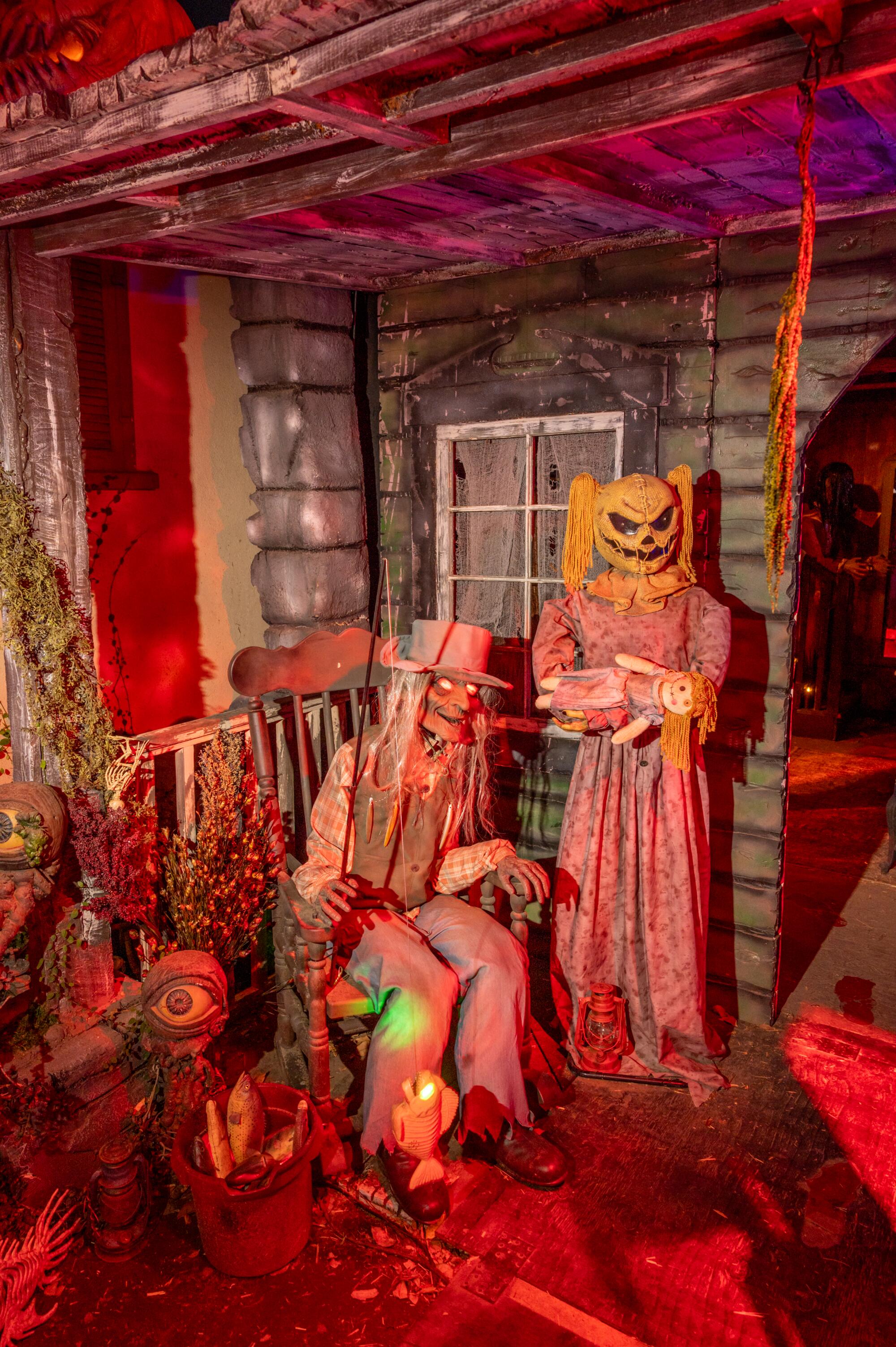 Two ghoulish figures on the porch of a haunted house.