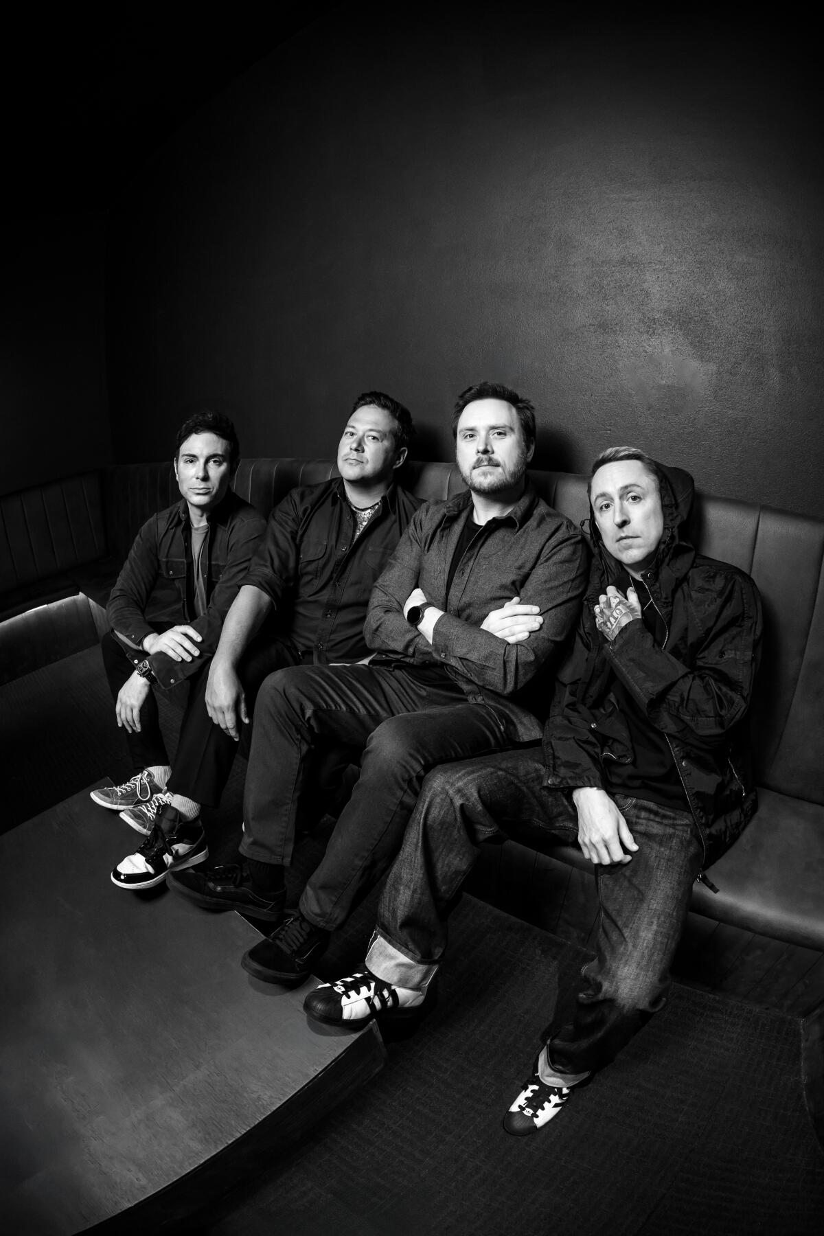 Yellowcard members sitting on a couch