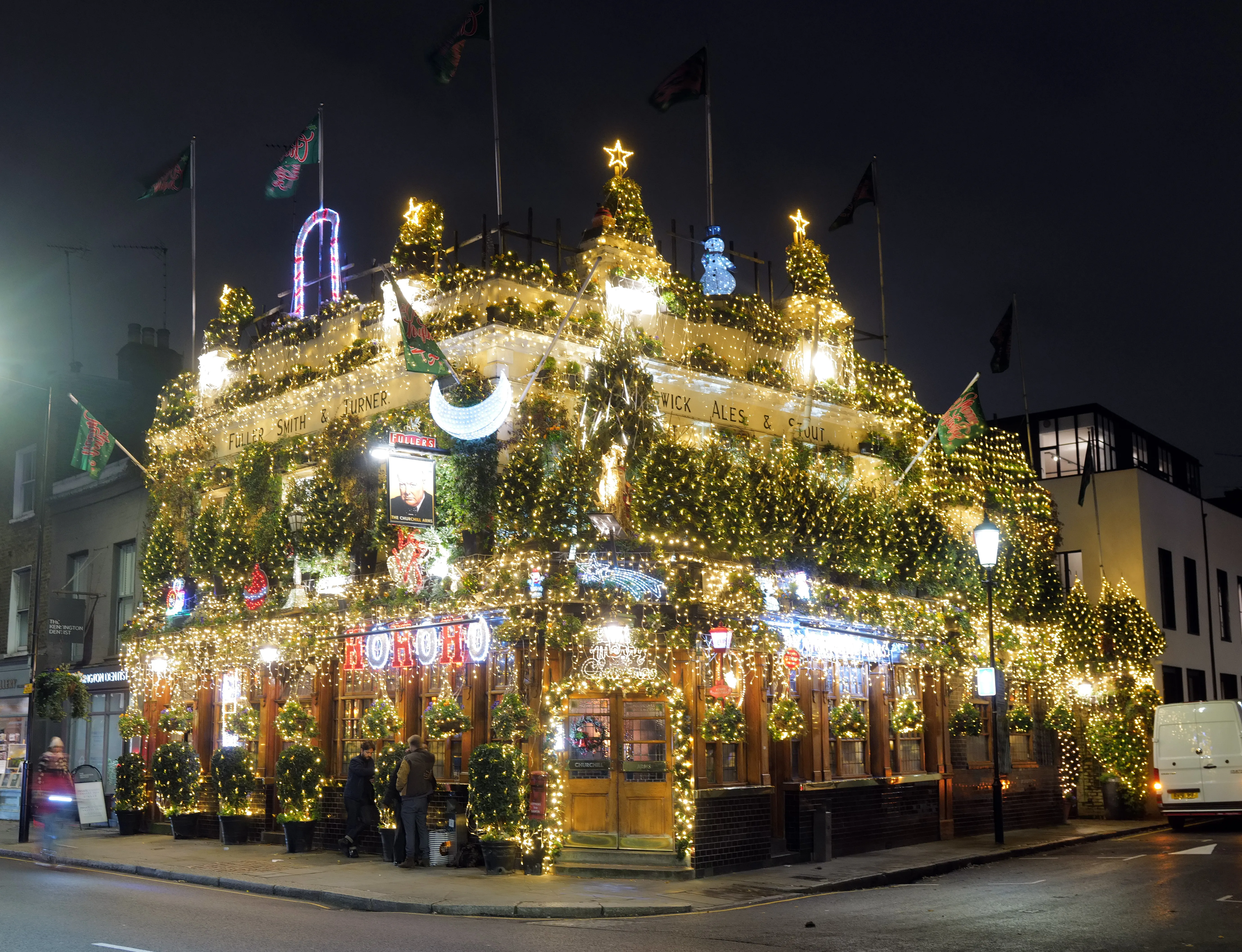 The Churchill Arms Pub in Kensington, covered in thousands of Christmas lights at night.