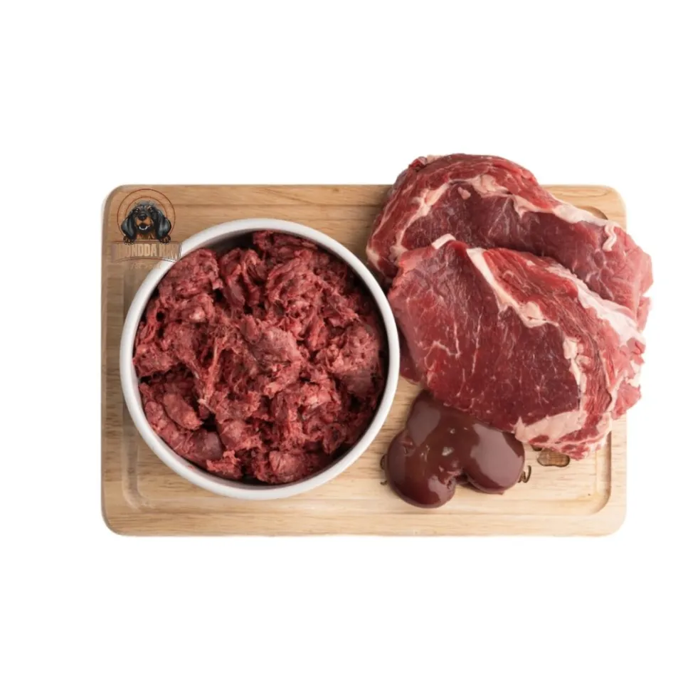 Raw meat in a bowl and two cuts of meat with a liver on a cutting board.