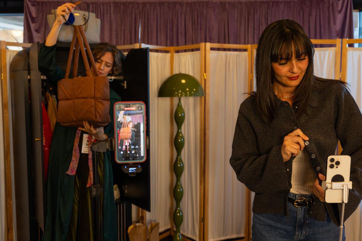 YouTube content creators Diana Extein, left, and Candice Waltrip, right, film clothing try-ons during YouTube's Holiday House shopping event at Google Spruce Goose on Thursday, Oct. 16, 2025 in Playa Vista, CA.