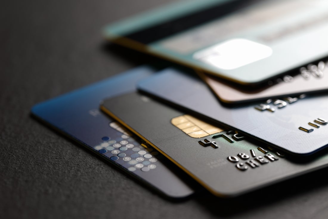 Stack of credit cards lying on a black table.