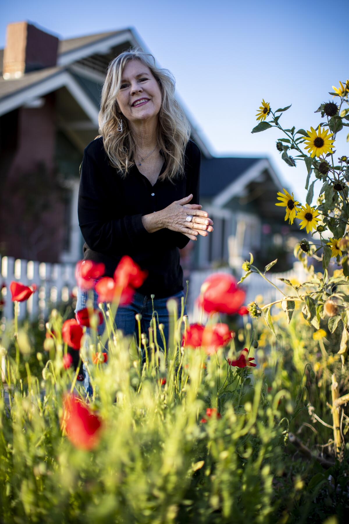 Susan Straight stands in front of her house amid poppies.