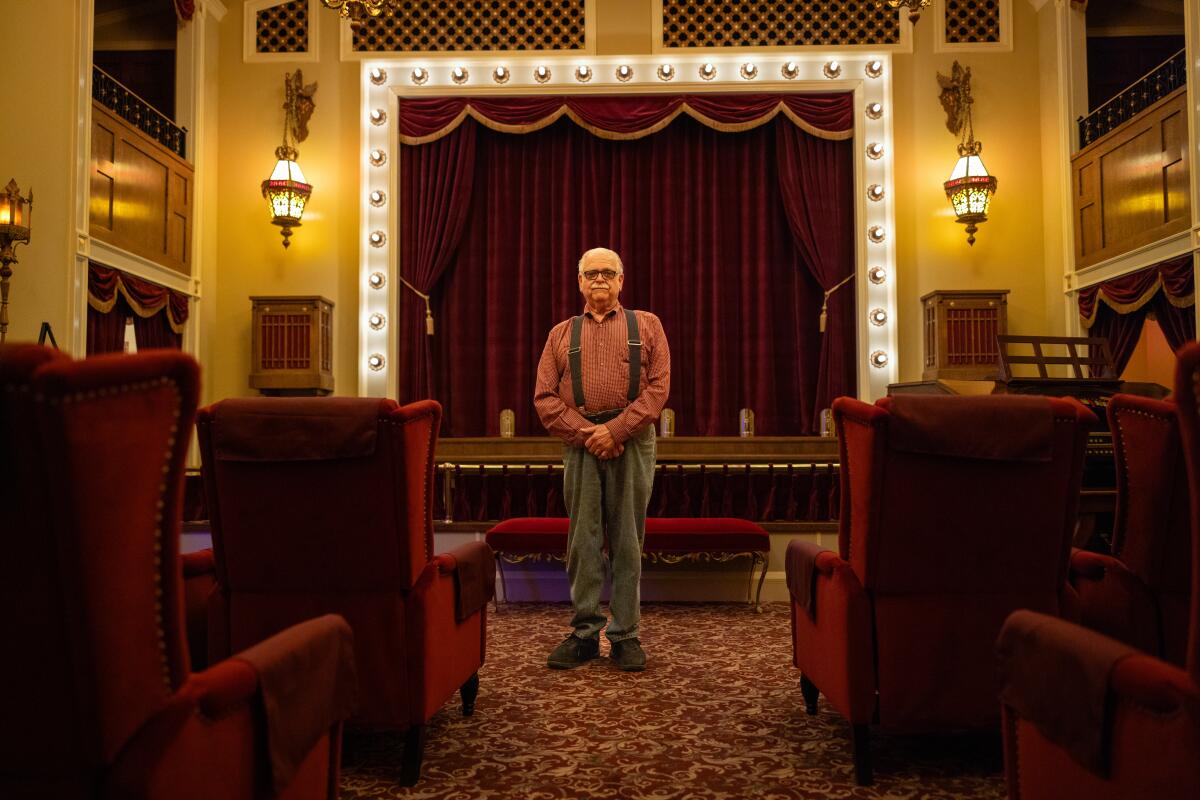 A man stands in a theater in the museum wing of his home 